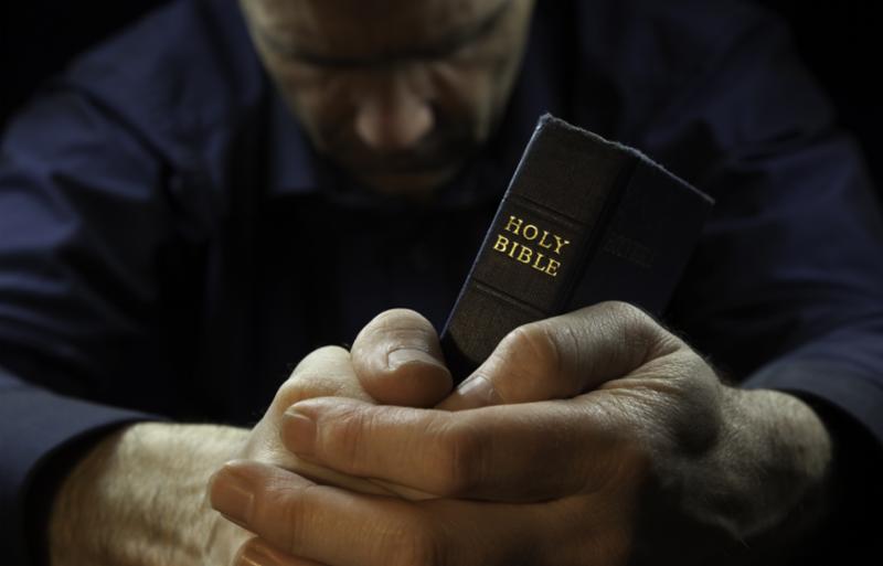 man_praying_holding_bible.jpg